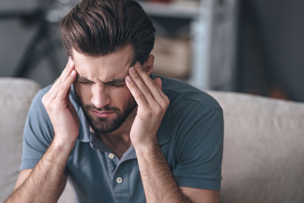 Guy experiencing migraine after recent car accident that's leading to blurred vision and dizziness as well. He should seek chiropractic treatment immediately.